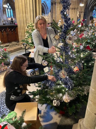 Emma Dermody, manager of The Auction Café, decorating the tree with Richard Winterton Auctioneers' operation manager Michelle Micklewright.