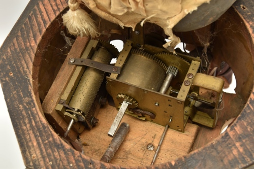 The elaborate pedestal on which the figure is seated encloses the spring-driven automaton and cylinder musical box mechanisms.