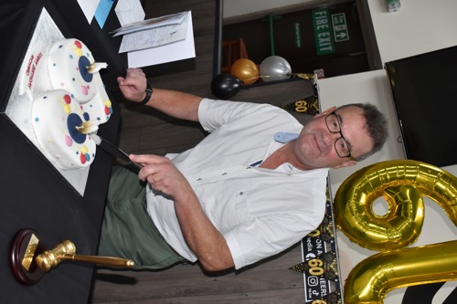 Richard cuts the cake.