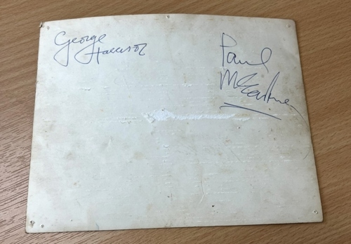 George Harrison’s and Paul McCartney’s signatures on the back.
